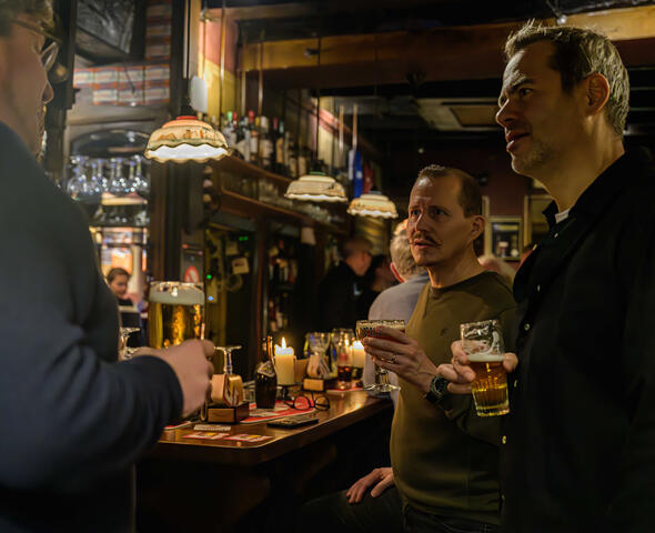 Olly Ceulenaere in gesprek aan de toog van een gezellig Gents café