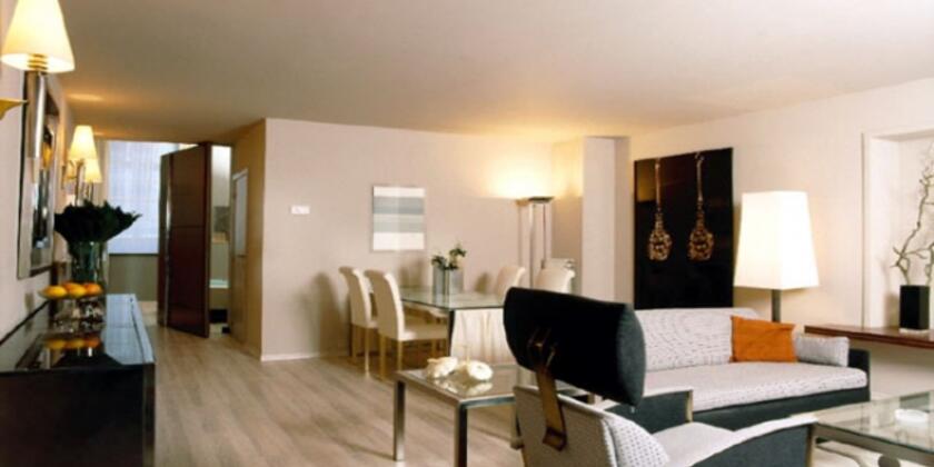 Modern appartement met eettafel, zetels, salontafel, in lichte kleuren.
