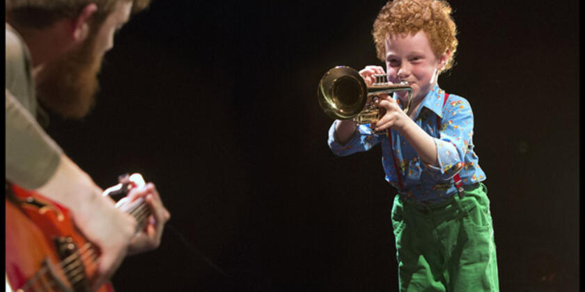 Kindje speelt op een trompet.
