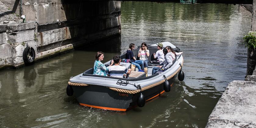 Huurboot met passagiers op de Leie, vaart onder Napoleon de Pauwbrug.