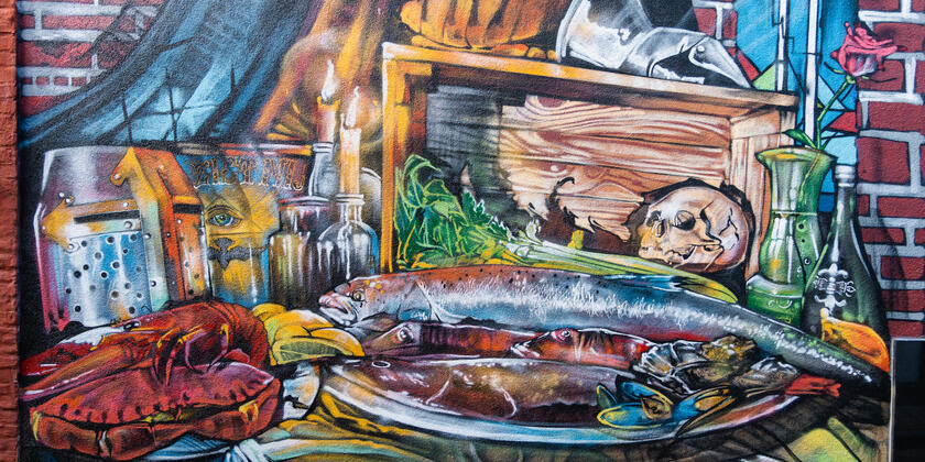 Kleurrijke muurschildering van verschillende etenswaren zoals vis, oesters en kreeft