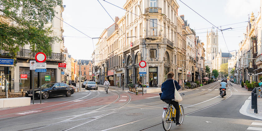 Menschen auf einem Fahrrad und einem Moped im Stadtzentrum