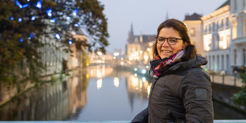 Lieve Staes poses with the light artwork 'The Blue Birds' by Maurice Maeterlinck along the water in Ghent.