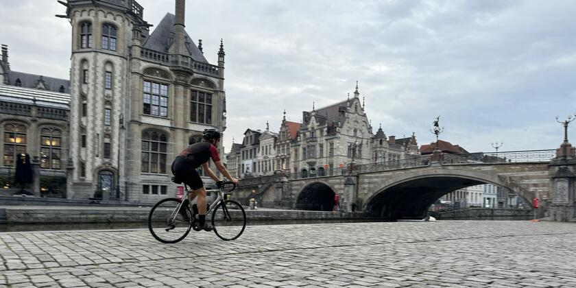 wielrenner rijdt over de kasseistenen aan de Korenlei