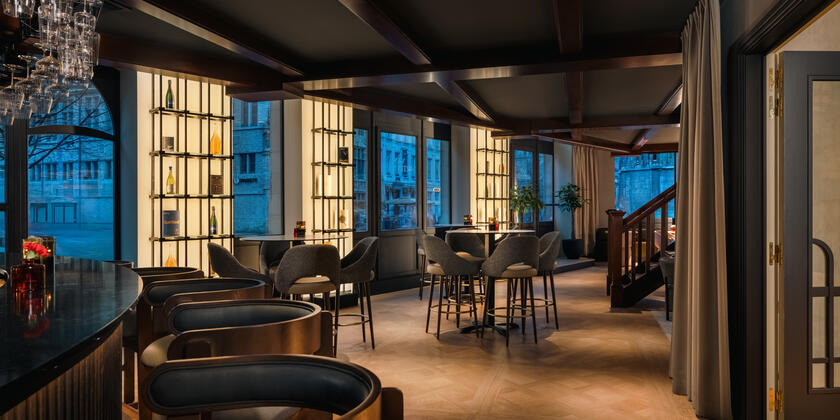 Bar with high bar stools in the NH Collection hotel in Ghent at dusk