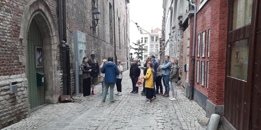 Grupo de personas de pie en medio de una calle sin tráfico