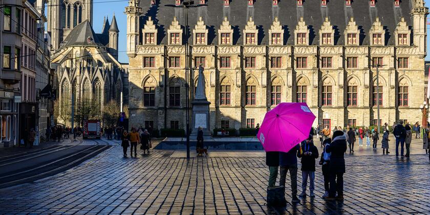 Persoon met een paarse paraplu op het Sint-Baafsplein