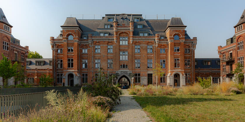 View from the courtyard garden of a large brick building with a slate roof