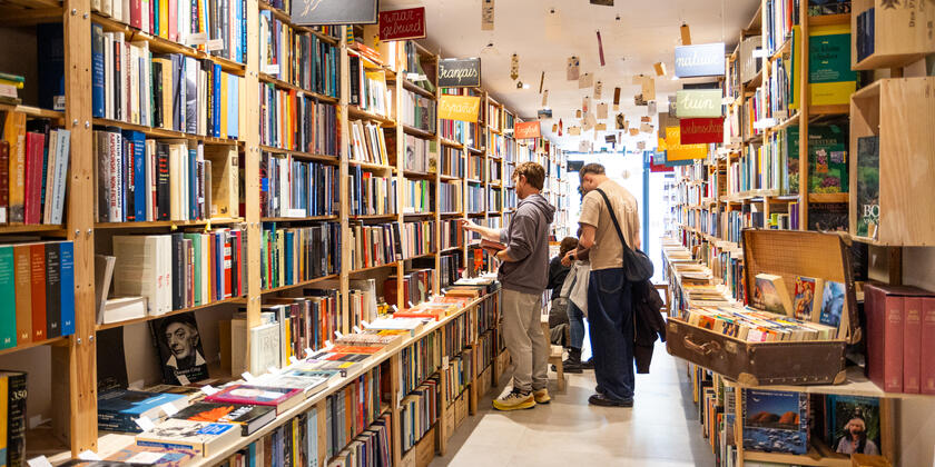 2 personen staan te kijken naar een kast vol boeken