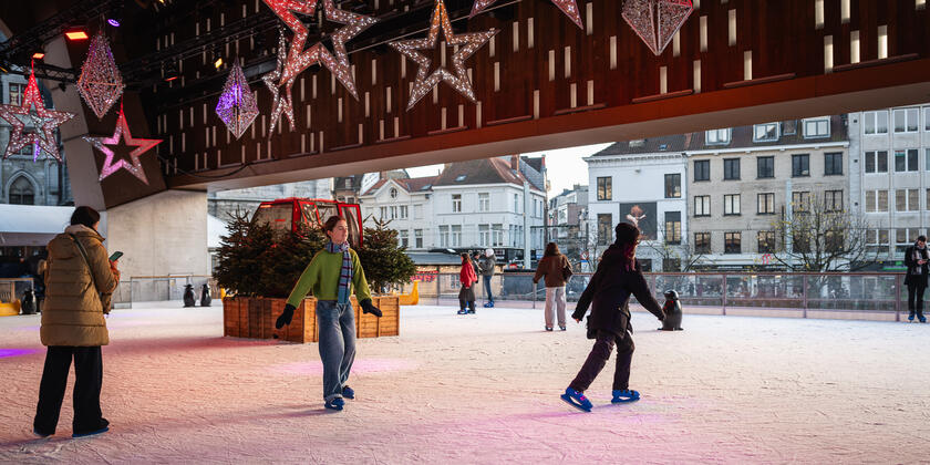 Mensen aan het ijsschaatsen in Gent onder de Stadshal