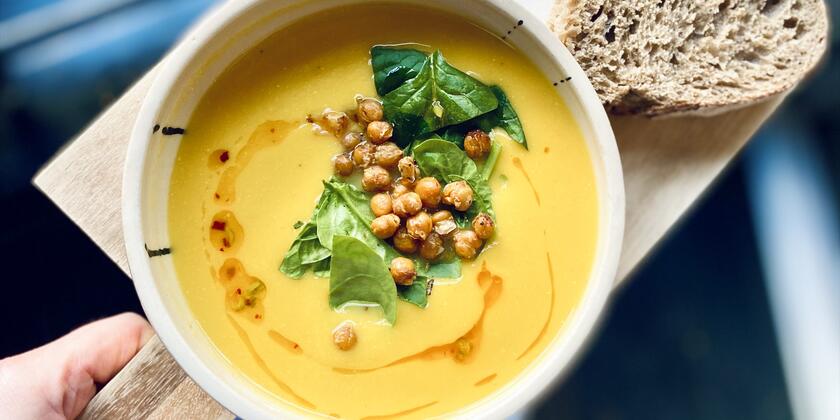 Un bol de soupe sur une table avec un morceau de pain