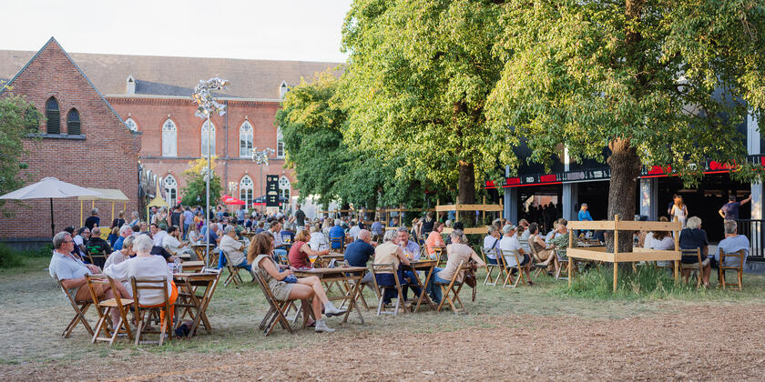 Mensen in de tuin aan een tafel tijdens het Gent Jazz Festival