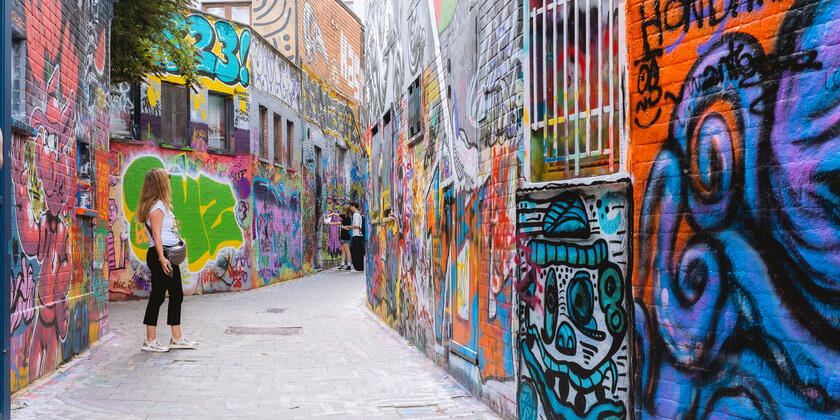 Vrouw aan het kijken naar de streetart in het graffitistraatje