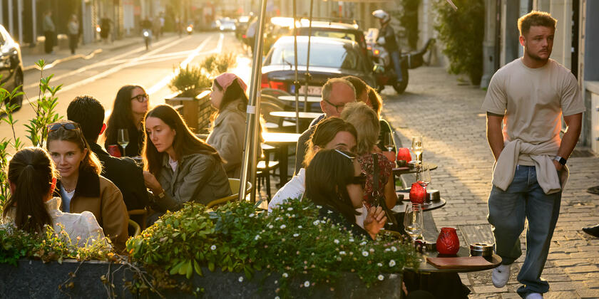 Mensen op het terras tijdens een zonnige herfstavond