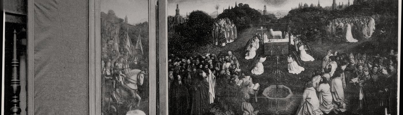 zwart-wit foto van man die naar missend paneel van het Van Eyck schilderij wijst 