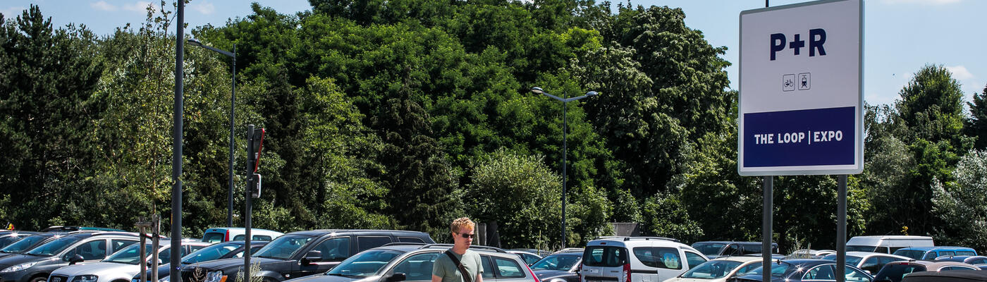 Un jeune homme passe devant l'entrée du Park&Ride à The Loop/Expo