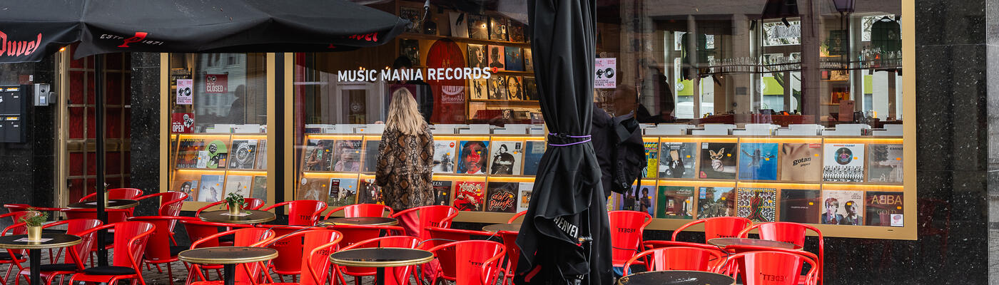 Terras met rode stoelen aan een platenwinkel