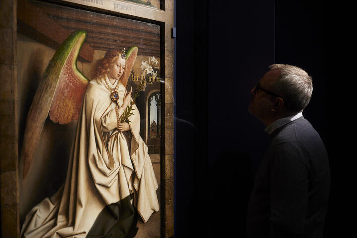 een man die naar een schilderij van de engel gabriël kijkt