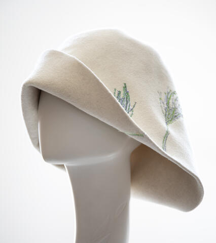 een witte hoed met 2 groene planten op