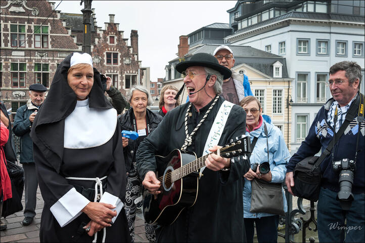 Ludieke gids verkleed in een zingende pastoor samen met een dame verkleed als non