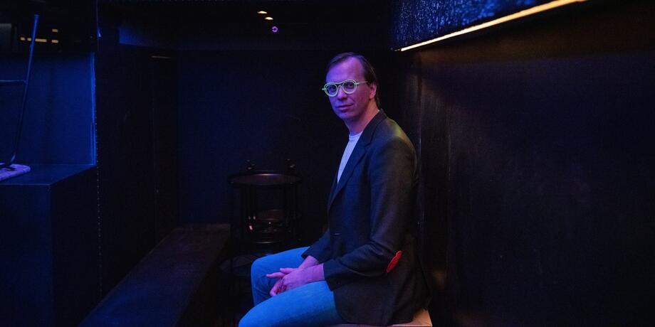 Ben Van Alboom zittend in een donkere en lege nachtclub