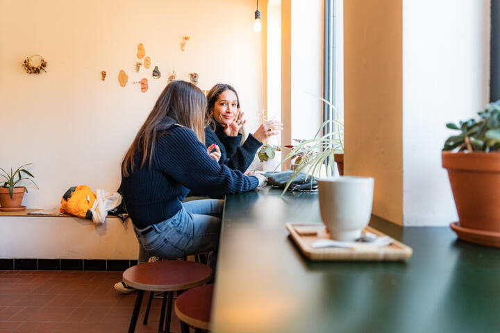 Tiany Kiriloff y su hija disfrutan de un café frente a la ventana de una acogedora cafetería en Gante