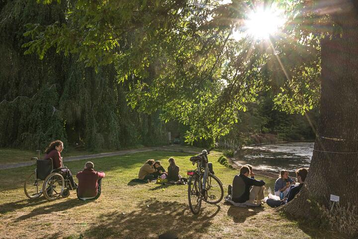 ©Stad Gent - Dienst Toerisme Mensen op het gras aan het water in de Plantentuin