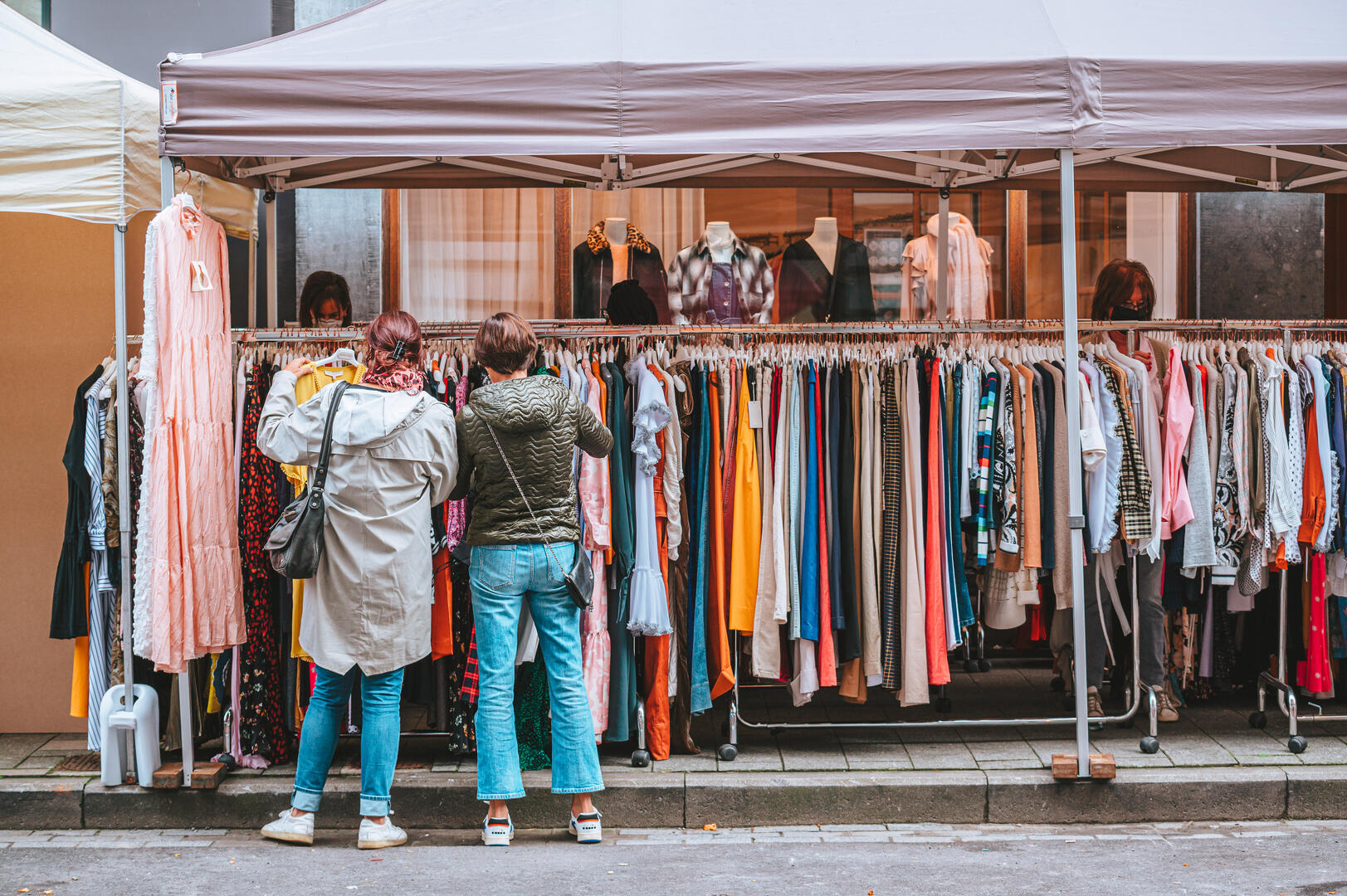 Deux dames choisissent des vêtements pendant la braderie publique.