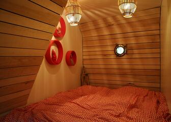Hotelkamer in de vorm van een kajuit met rode, witte en houten accenten.