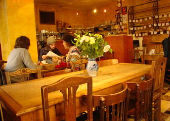 Interieur sandwichbar met mensen aan een houten tafel die een menu bekijken.