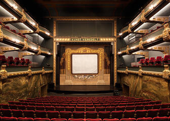 De Theaterzaal van Kunstencentrum Vooruit met rode zetels en het podium.