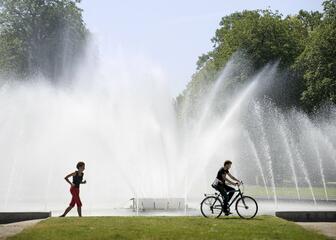 Een fietser en loper bij de fontein in het Koning Albertpark. 