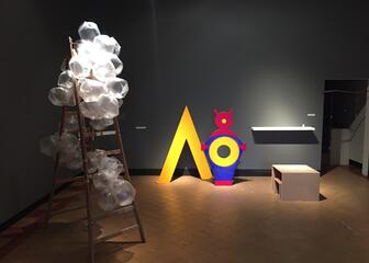 Kunstwerk met ladder en plastic zakjes en 2 felgekleurde kunstwerken