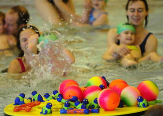 Close-up van spelende kinderen met ouders in Zwembad Strop.