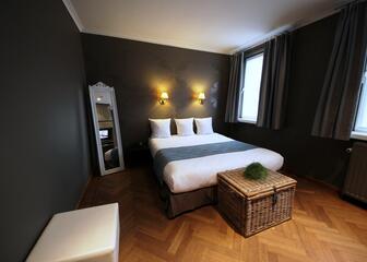 Comfort tweepersoonskamer in Hotel Astoria met vooral donkerbruine tinten.