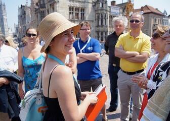 Gids met groepje zomers geklede toeristen op de Sint-Michielsbrug.
