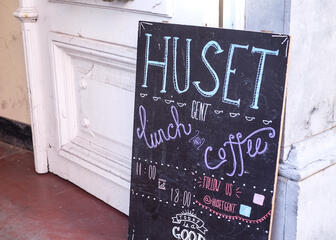 Krijtbord met opschrift "lunch and coffee" aan de ingang van Huset.