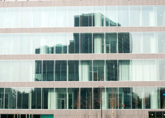 Gerechtsgebouw, zoom op ramen van het ene gebouw waarin ander gebouw weerspiegeld is.