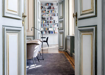 Gerenoveerde kamer van het statige stadshotel met bibliotheek: limoengroene deuren en mooie lichthouten vloeren.