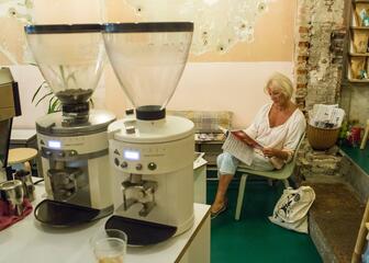 Vrouw die een tijdschrift leest in koffiebranderij Vandekerckhove 