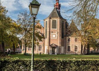 Sint-Elisabethkerk in het Oud Begijnhof met antieke groene lantaarnpaal en daar tegen leunend een fiets op de voorgrond.