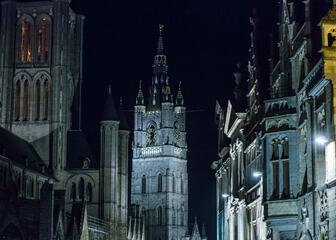 Nachtelijk zicht op de toren van de Sint-Niklaaskerk en het Belfort.