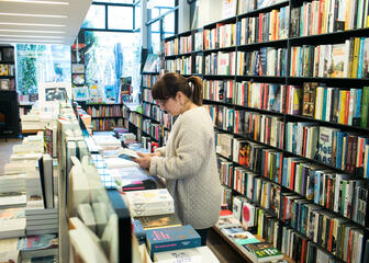 Vrouw die naar boeken kijkt in boekhandel Walry