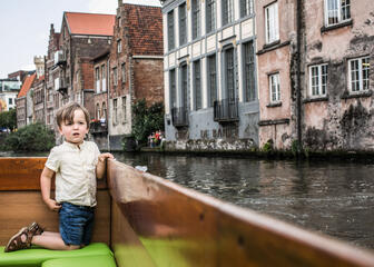 Een jongen zit op de watertram op de rivier.