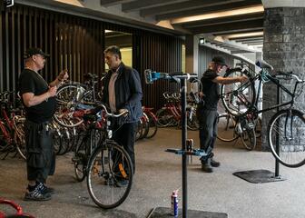 Twee fietsherstellers onder de Stadshal aan het werk.