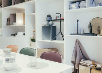 Showroom Nordic House Gent: witte wandkast gevuld met interieurvoorwerpen. 