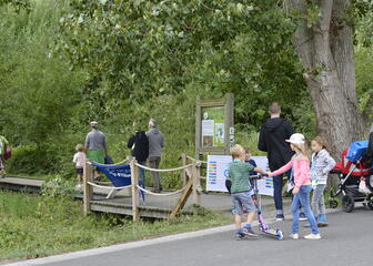 Kinderen en begeleiders aan een brugje in het natuurgebied.