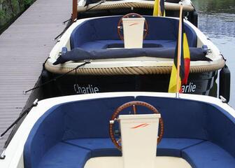 4 bootjes met blauwe bekleding en belgisch vlagje die aangemeerd liggen