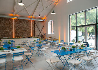 Grote zaal met zomers ingerichte setting, tafel en stoelen in blauw en wit