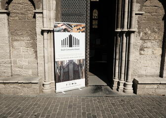 de deur van de st-niklaaskerk die half open staat, een bord met uitleg over een Bach concert